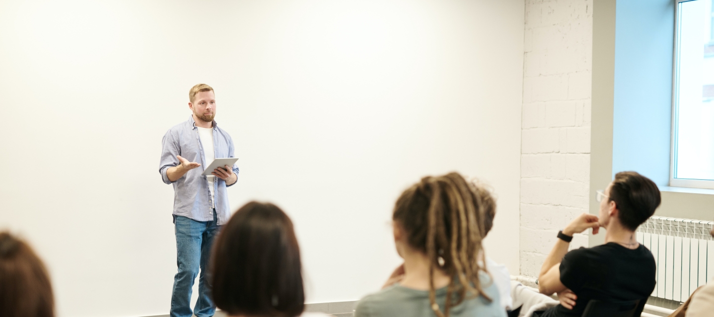 Standing student speaks at front classroom